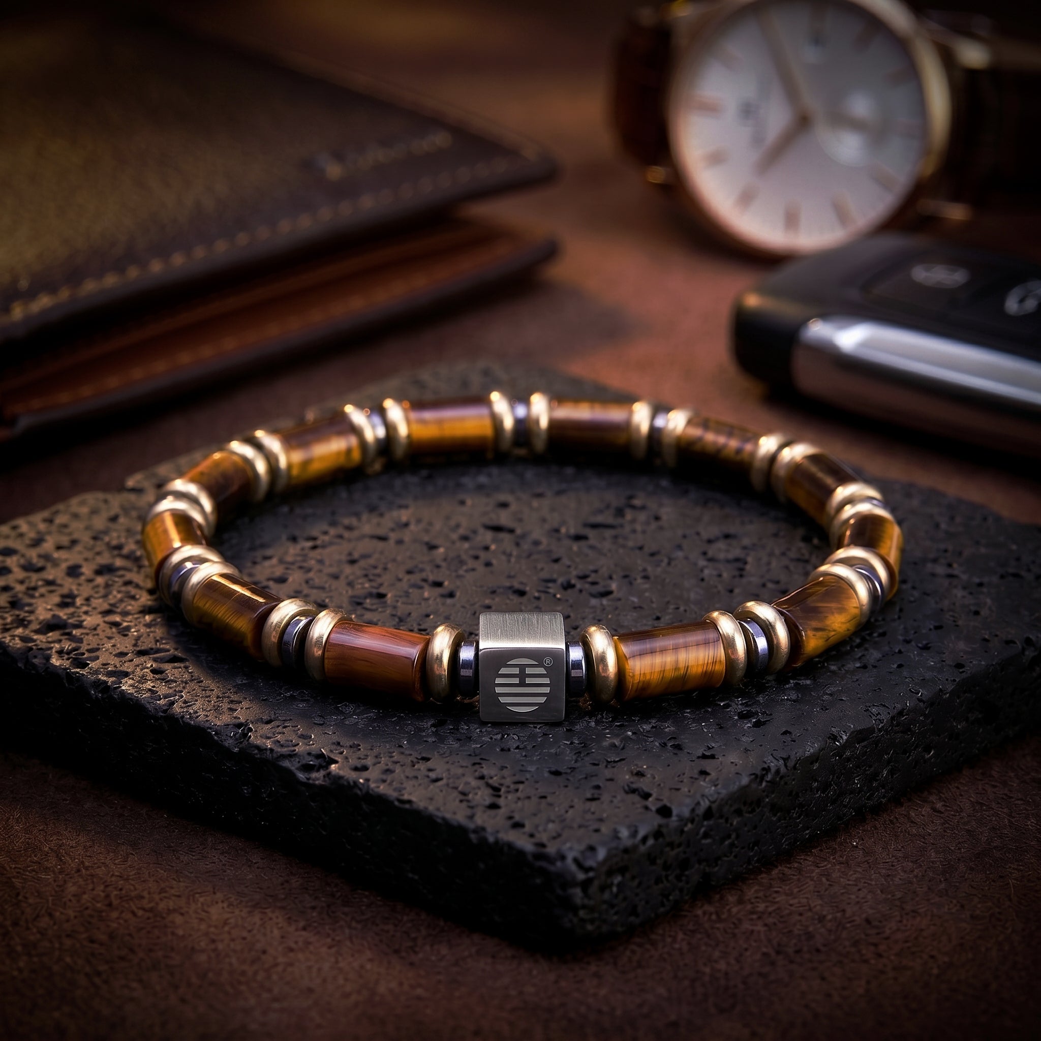 Bracelet with wooden beads on a dark stone surface, with a watch and phone in the background.