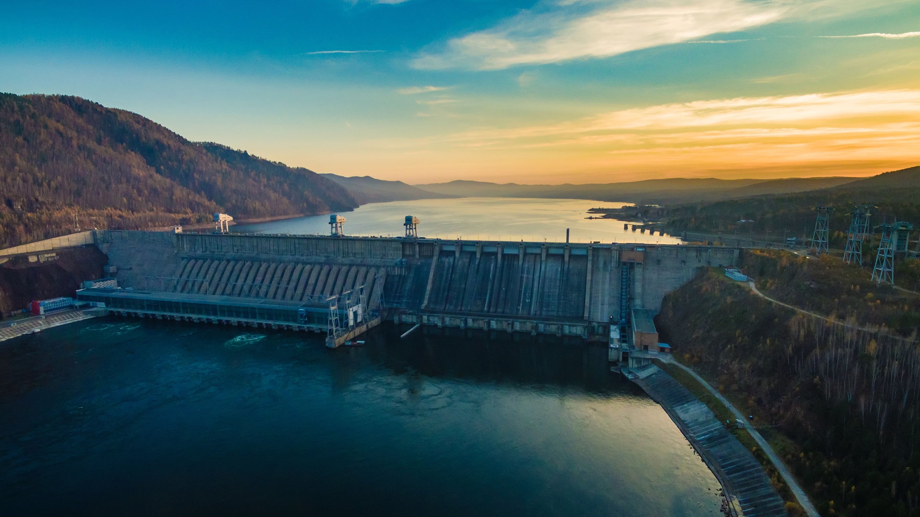 Large dam with a scenic landscape during sunset.