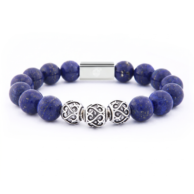 A beaded bracelet featuring deep blue lapis lazuli stones, three ornate silver Celtic knot beads, and a silver magnetic clasp, shown on a clean white background.