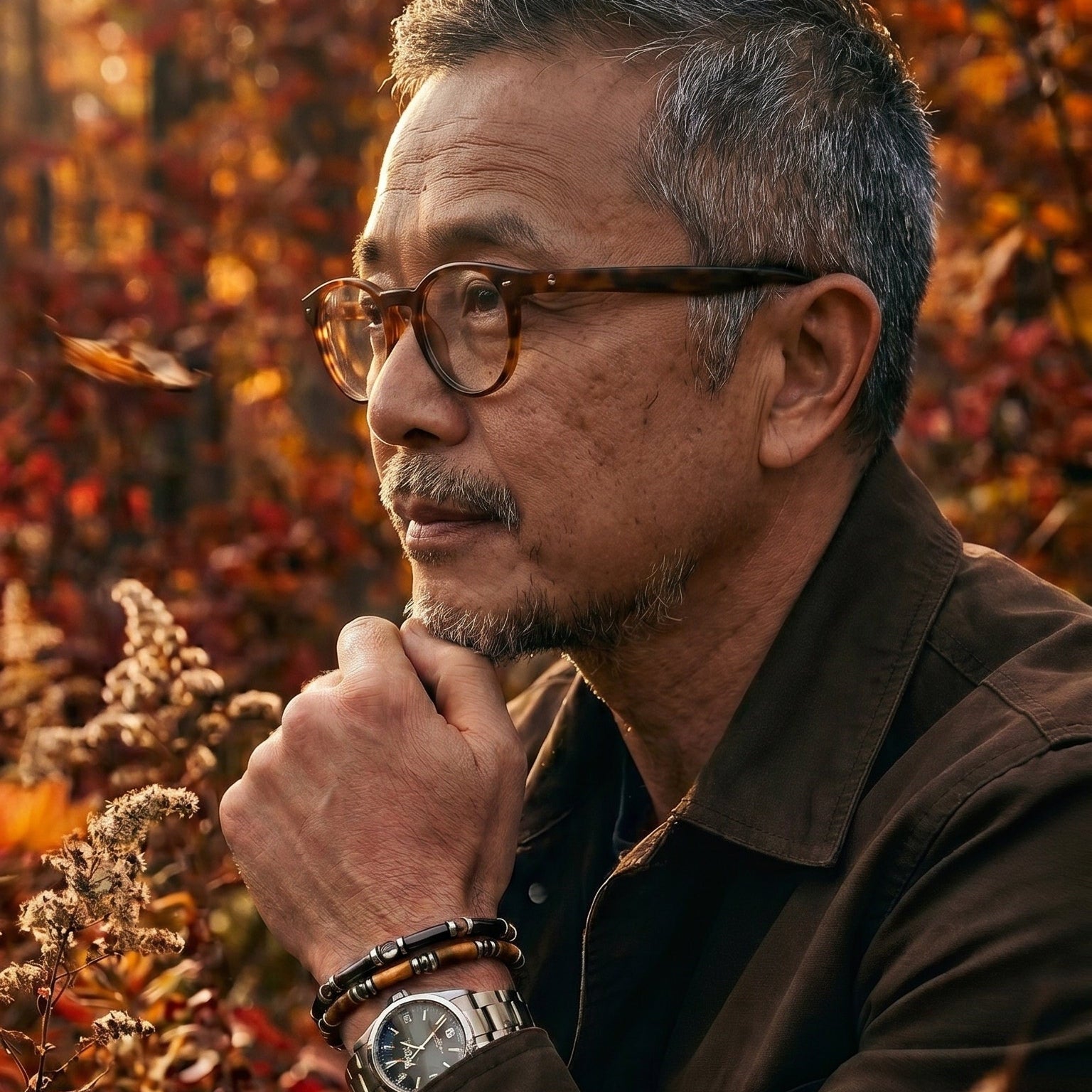 Man with glasses and a watch in an autumn setting